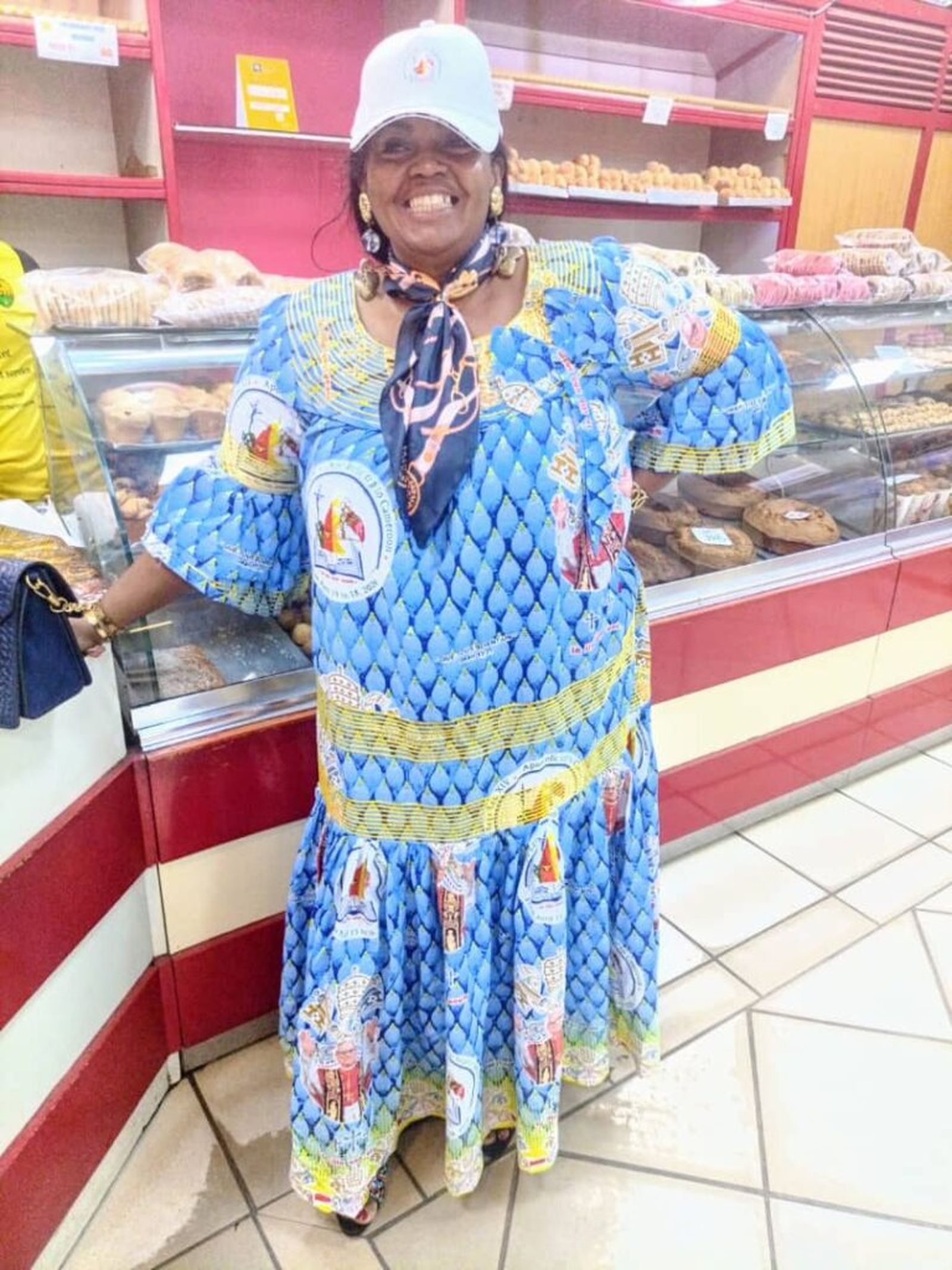 Una señora en una panadería de Yaundé esta misma mañana, con su vestido hecho con la tela oficial