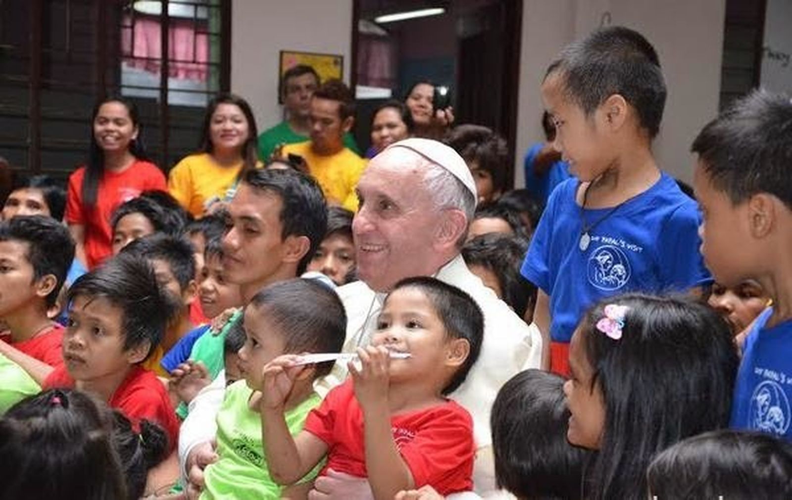 Papa, con niños de la calle en las rodillas