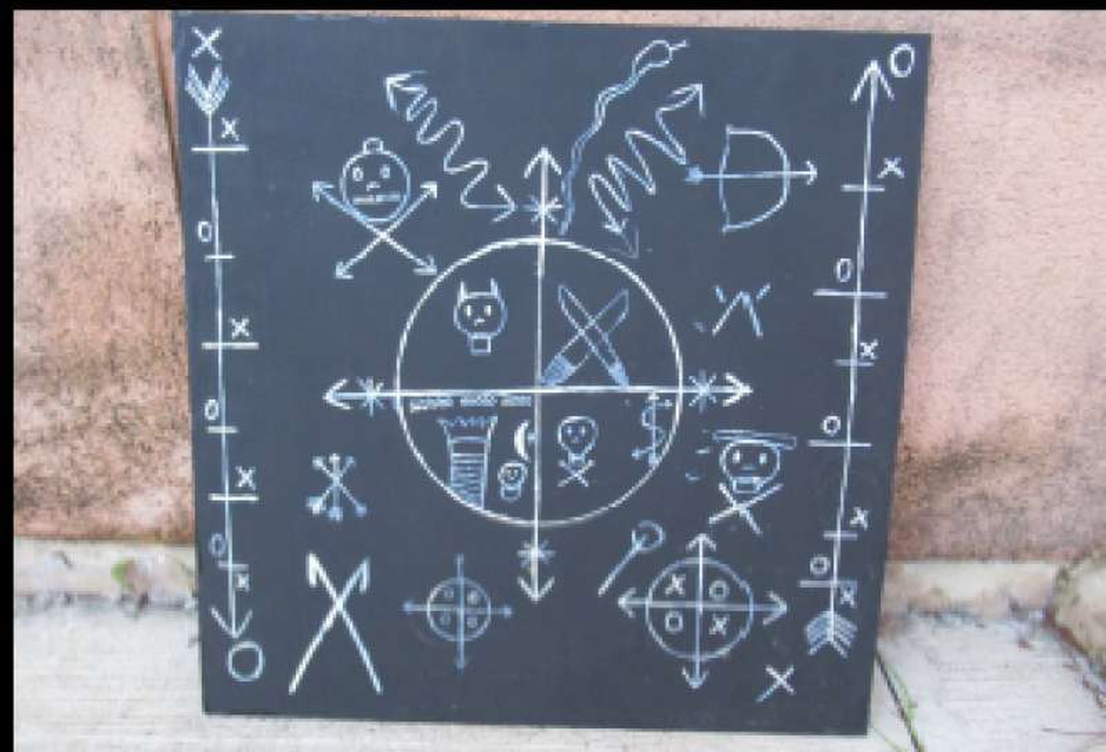 Signos del acto satánico dibujados en una lápida.