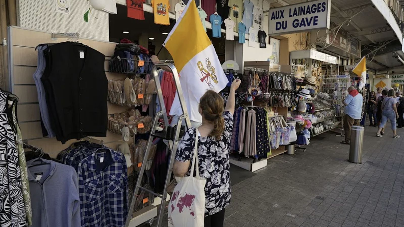 Una mujer mira una bandera del Vaticano en una tienda en Lourdes