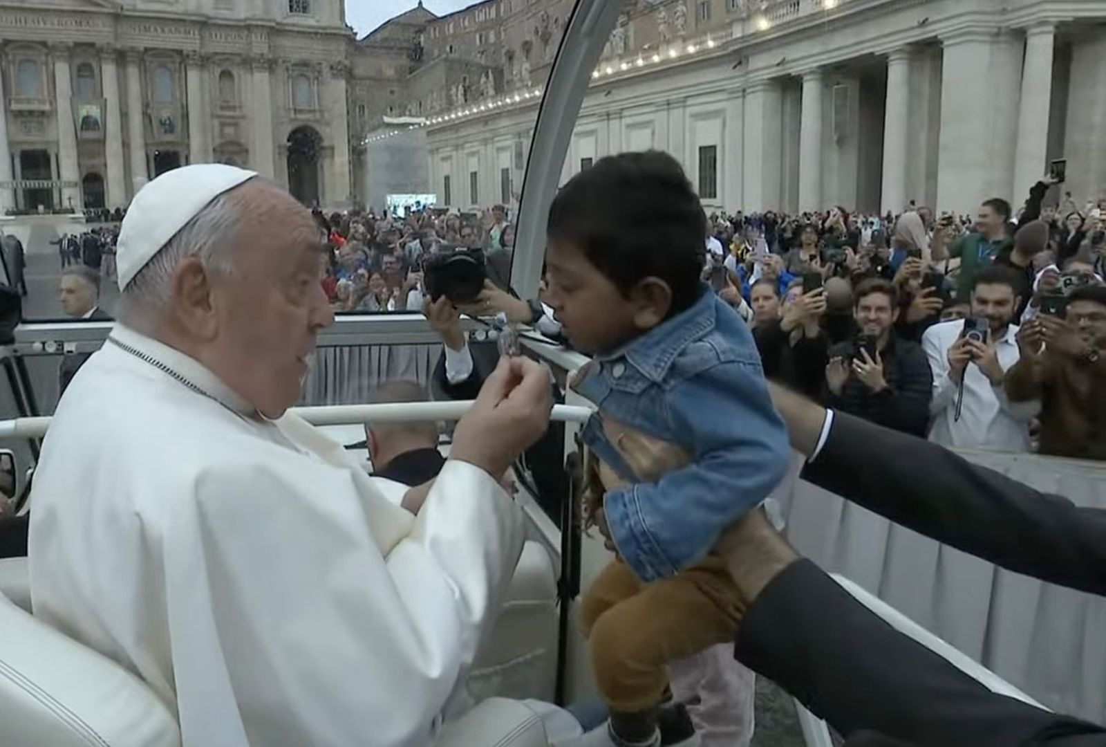 Francisco enseña una medalla a un niño