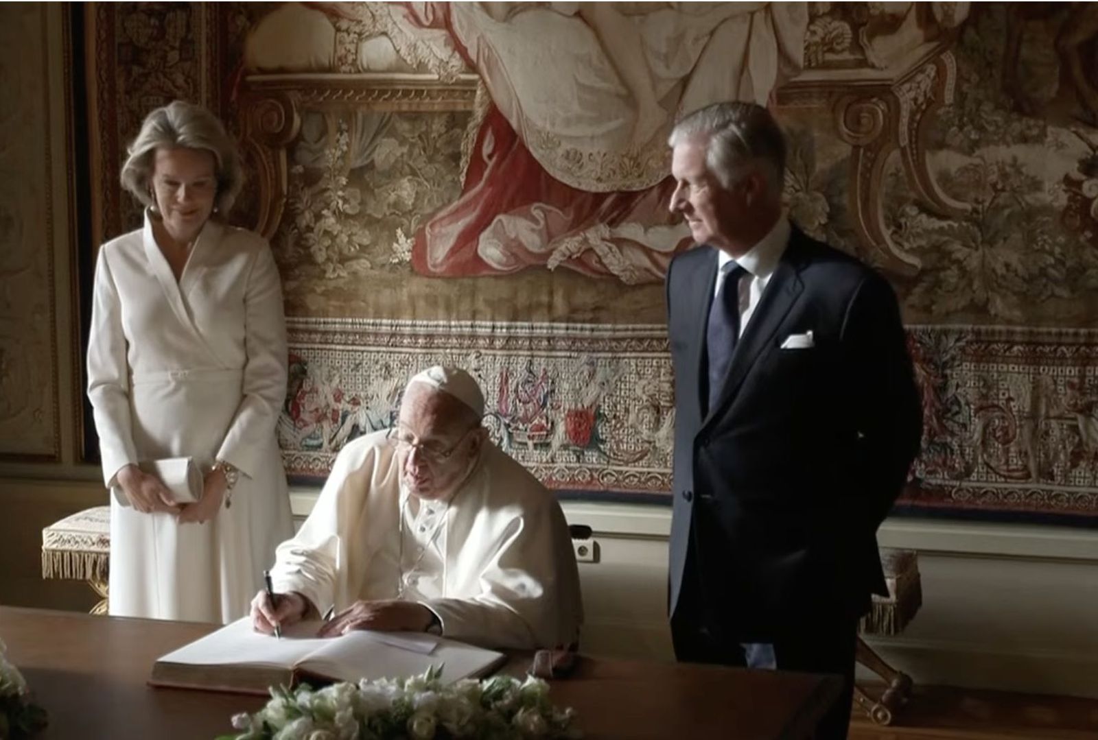 Francisco firma en el libro de honor ante los Reyes de Bélgica