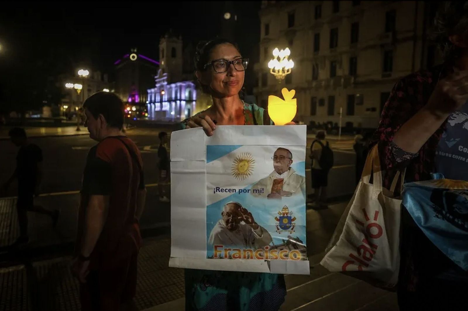 Una mujer sostiene un cartel del Papa frente a la catedral de Buenos Aires