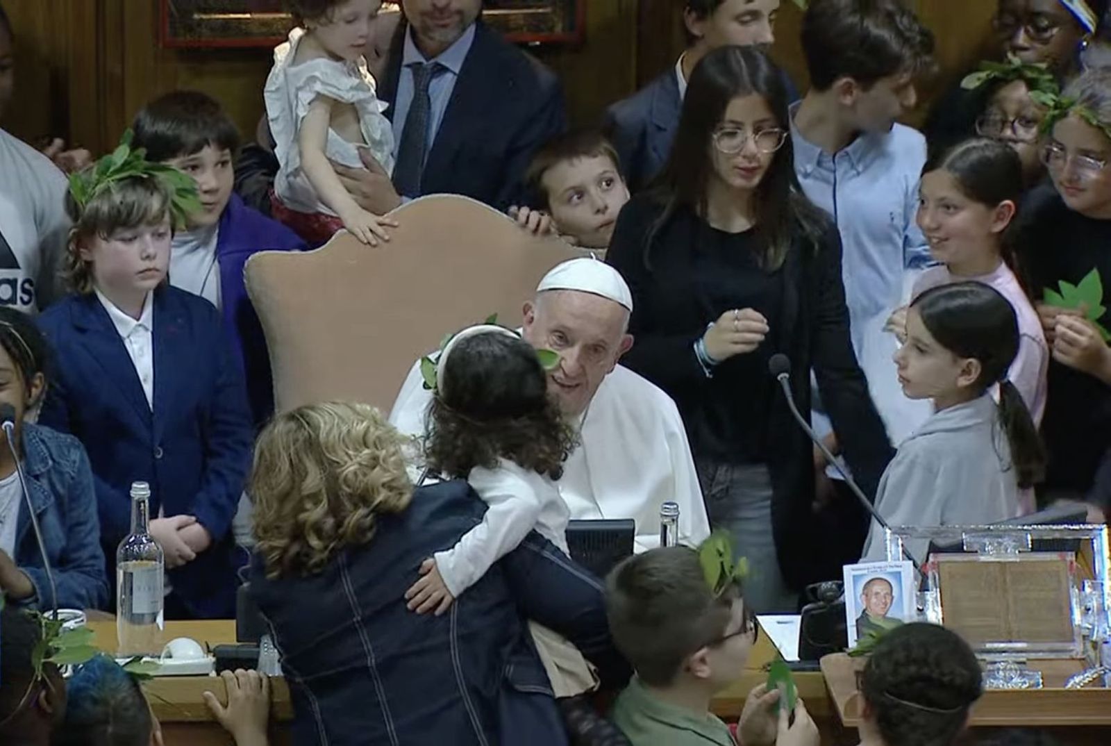 Una niña saluda al papa durante la mesa redonda con niños en el Aula del Sínodo