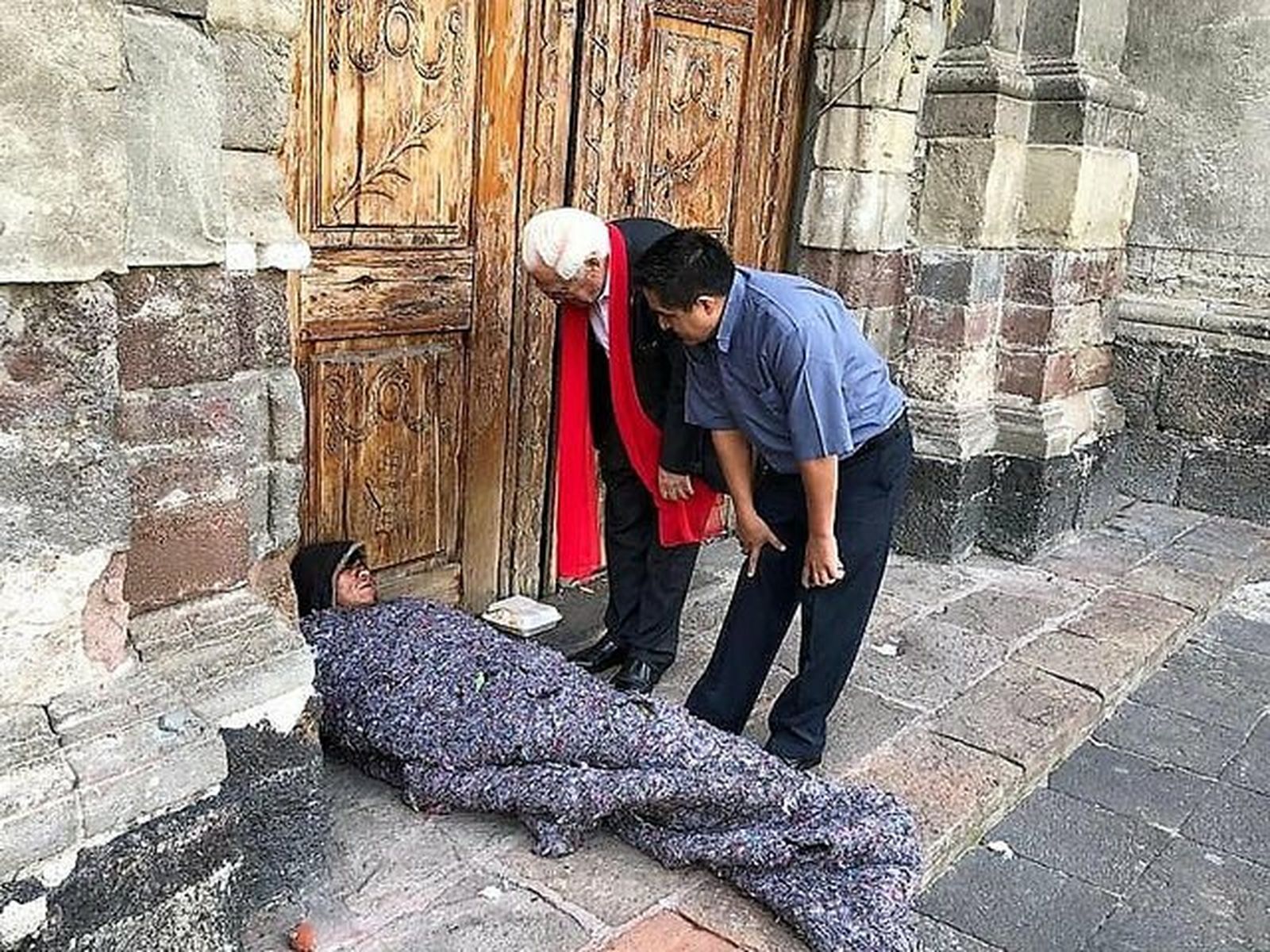 El padre Ángel y el padre Benito saludan a una persona sintecho