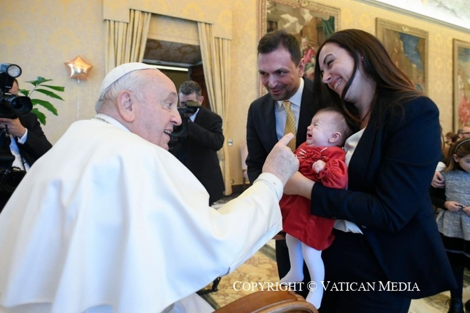 Francisco juega con un bebé en la audiencia de hoy