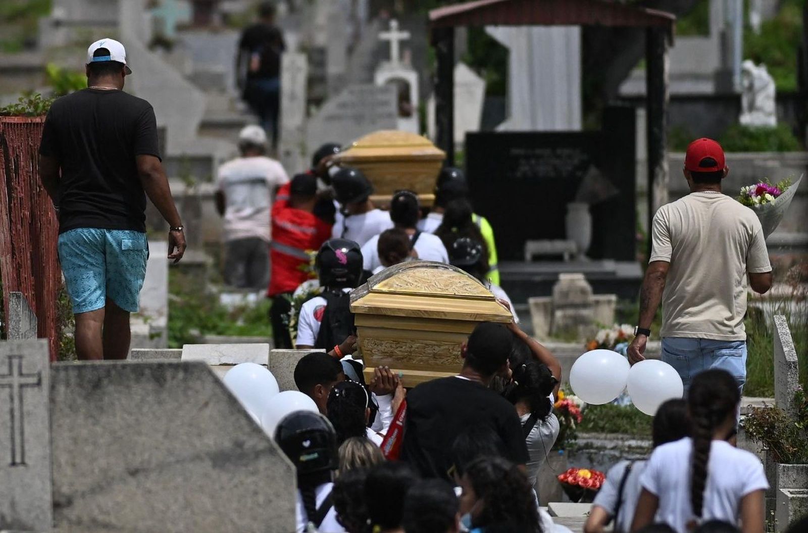 Familiares transportan los pequeños ataúdes de dos niños rescatados de entre las ruinas de su casa. Venezuela.
