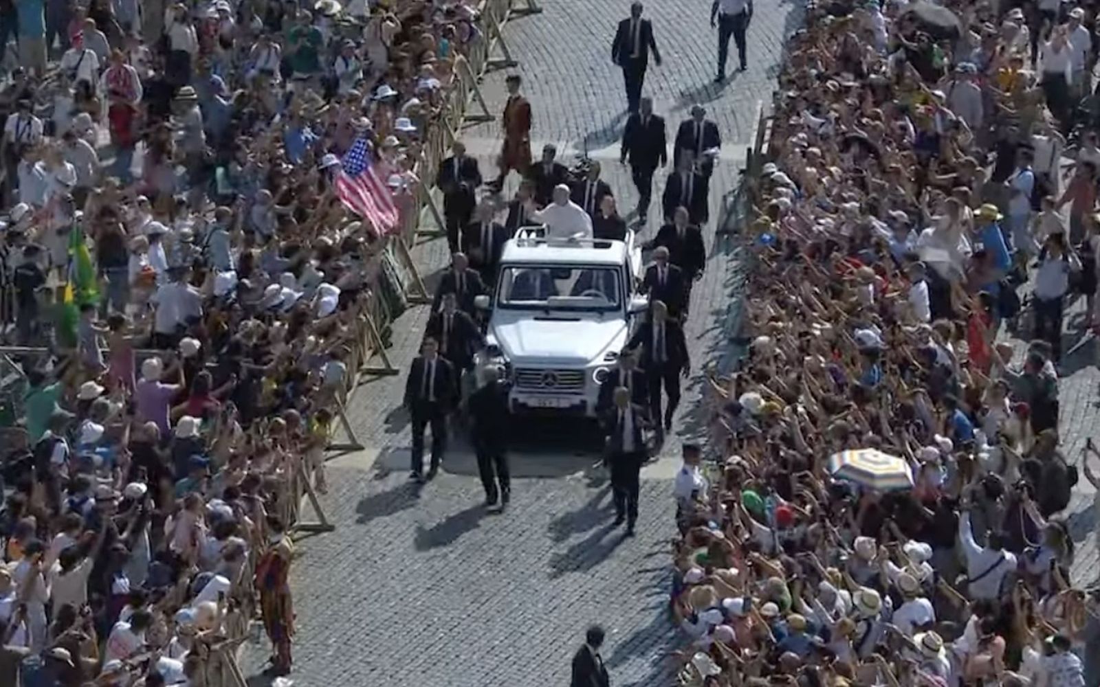 El Papa pasa ante una bandera de su país natal