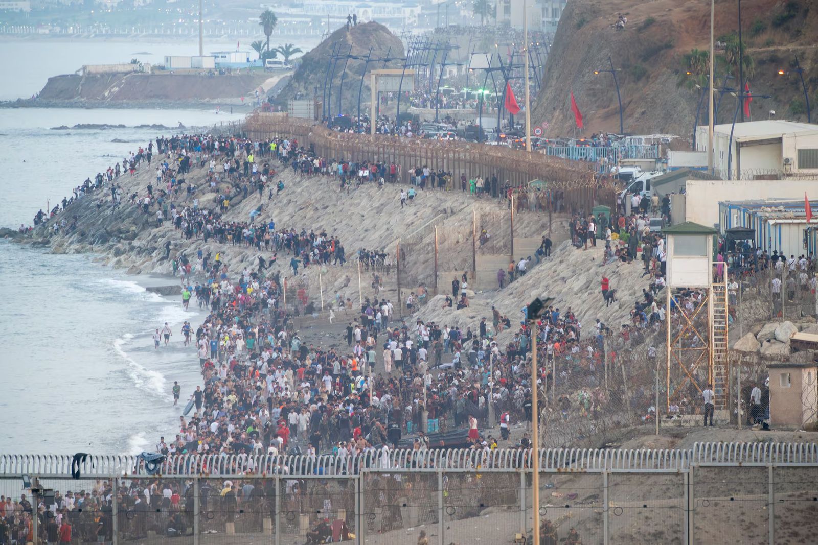 Decenas de migrantes intentan traspasar la frontera entre Ceuta y Marruecos, este viernes.