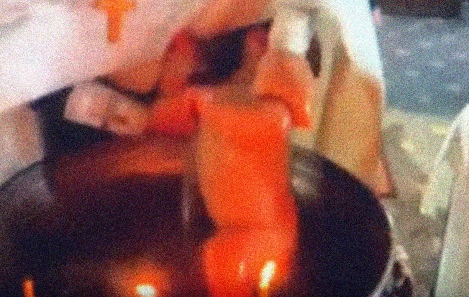 Un cura ortodoxo zarandea bruscamente a un bebé en un bautizo