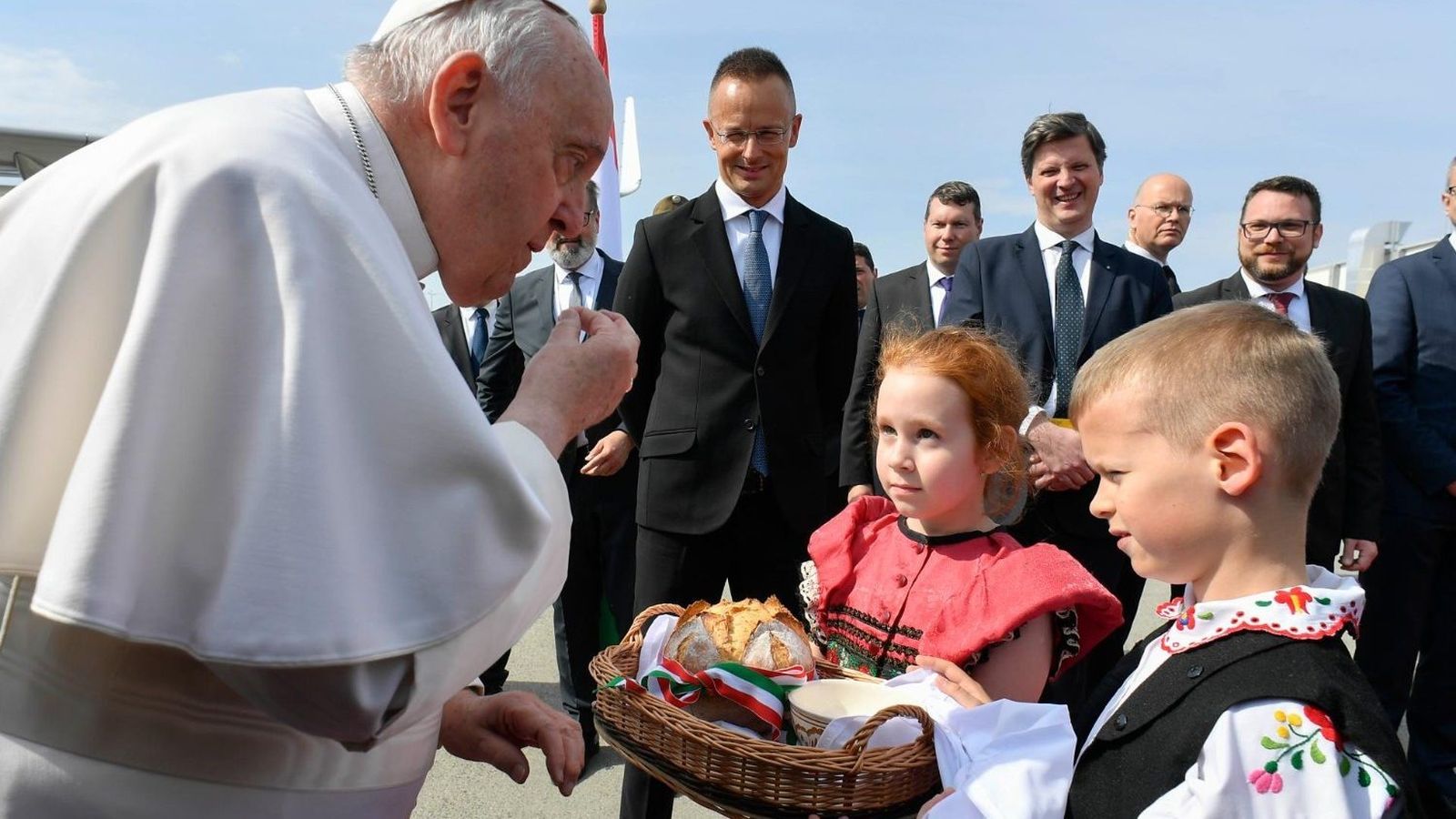 El Papa prueba el pan de bienvenida ofrecido por dos niños húngaros