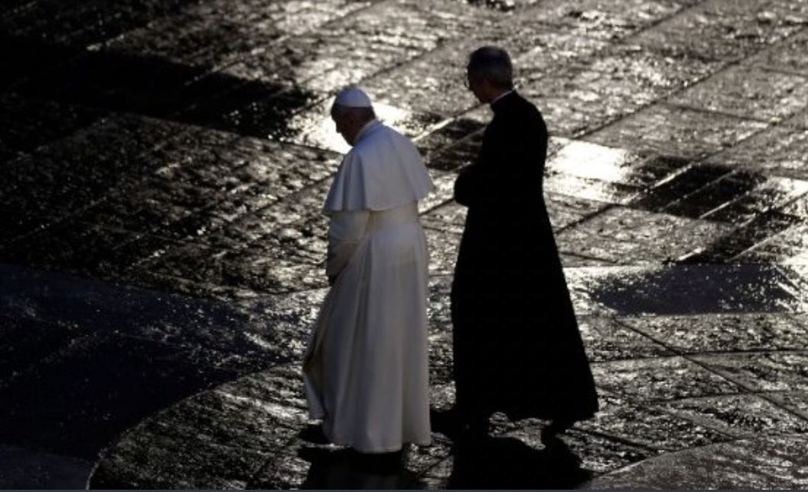 El Papa, con el ceremoniero, cruza la soliataria plaza de San Pedro