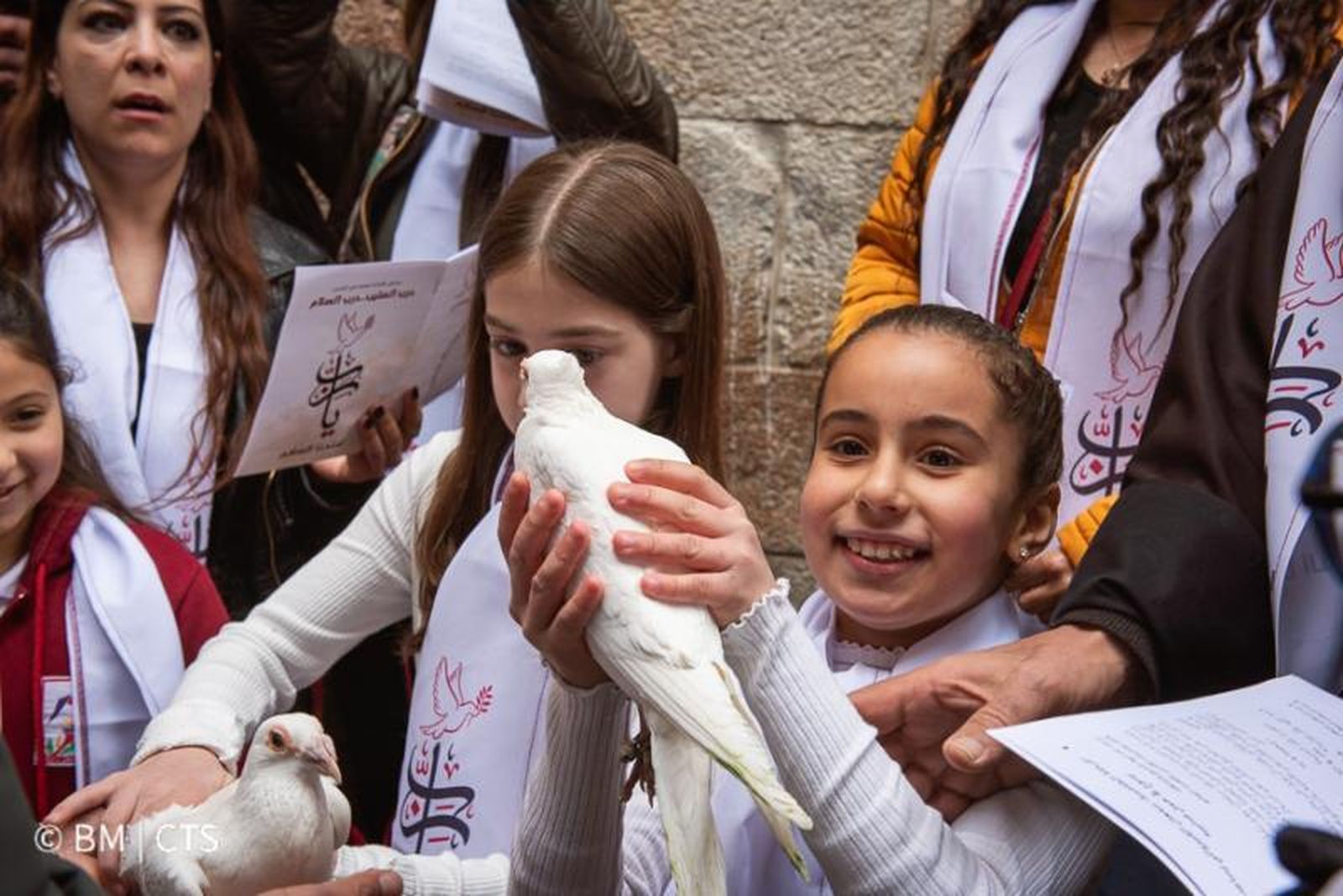 Dos niñas lanzan palomas durante el via crucis por las calles de Jerusalen