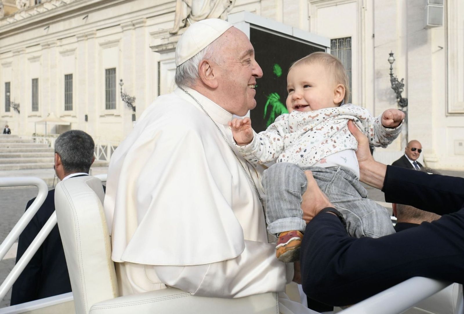 Francisco saluda a un bebé en la plaza de San Pedro