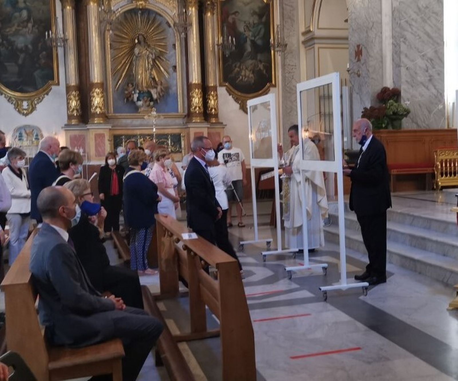 Dar la comunión tras mamparas de cristal