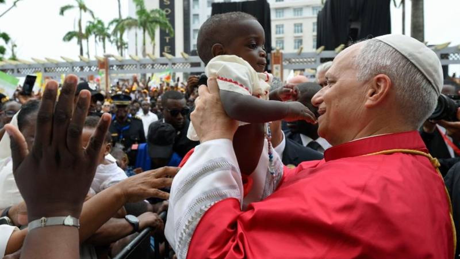 El Papa saluda a los fieles presentes y bendice a un niño fuera del Palacio Presidencial del Malabo