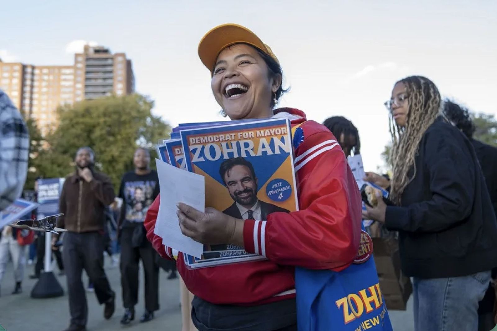 Una mujer reparte propaganda de Zohran Mamdani