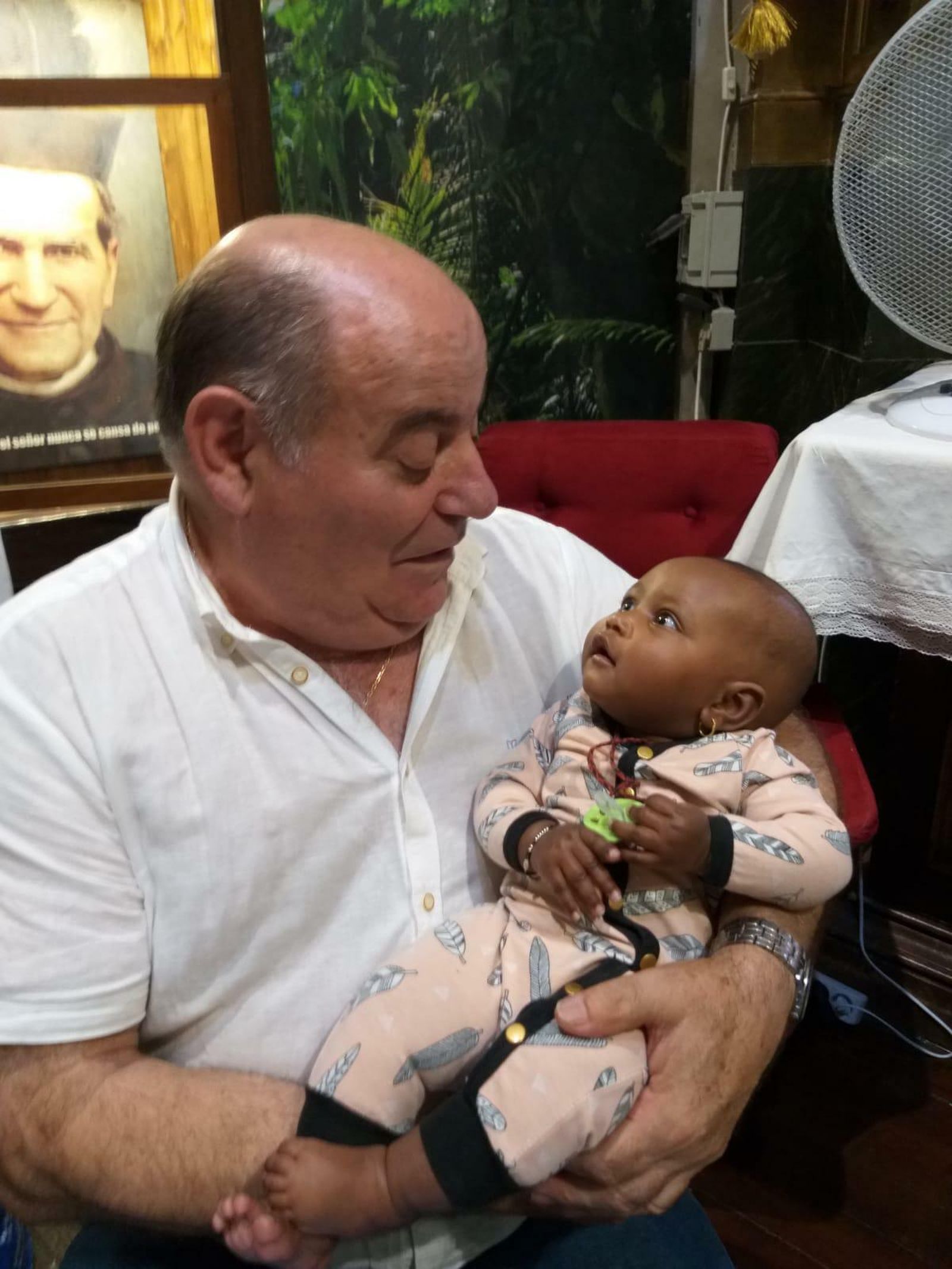 Uno de los curas de San Antón, con el bebé