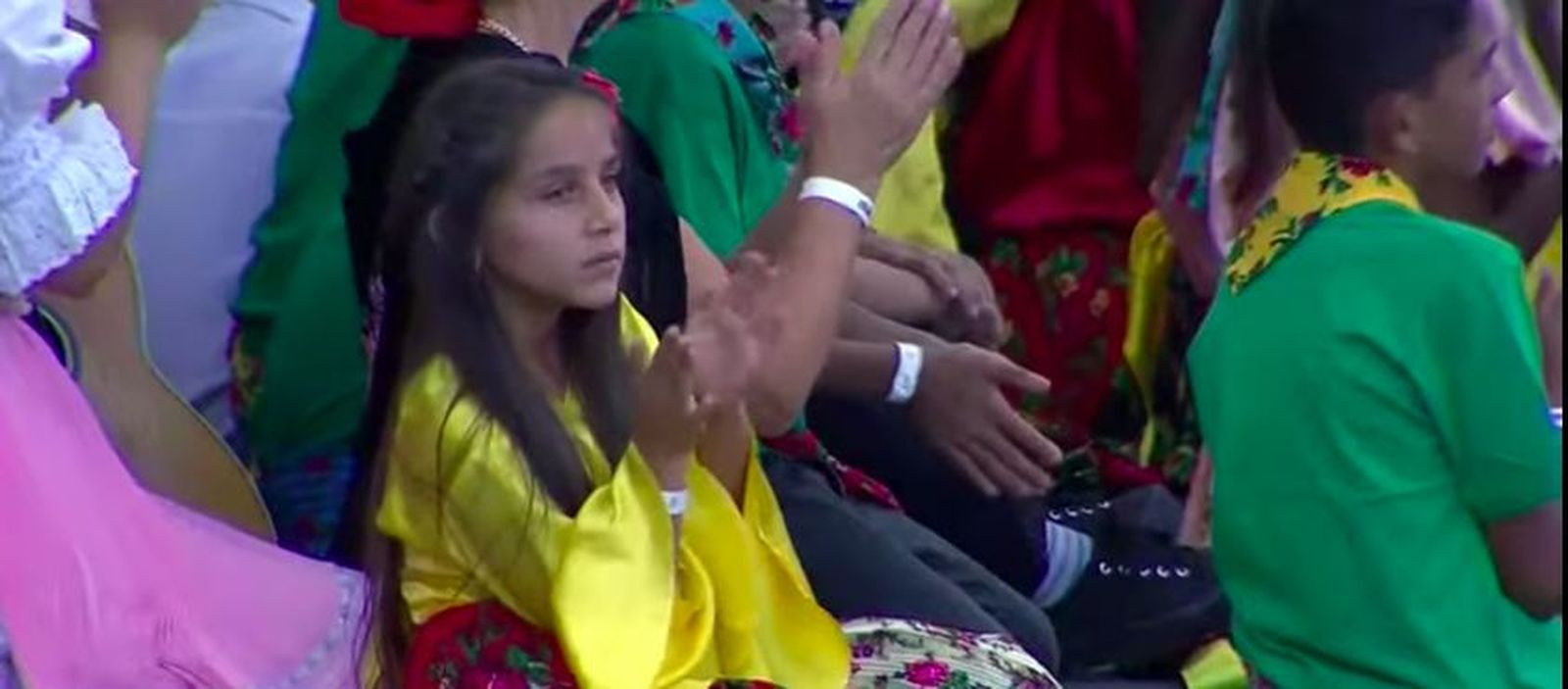 Un niña romaní escucha a Francisco