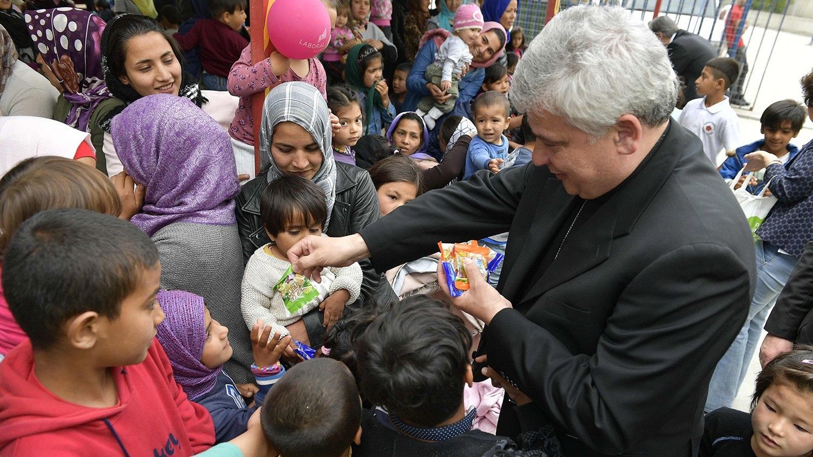 Konrad Krajewski durante su visita al campo de refugiados de Lesbos en 2019