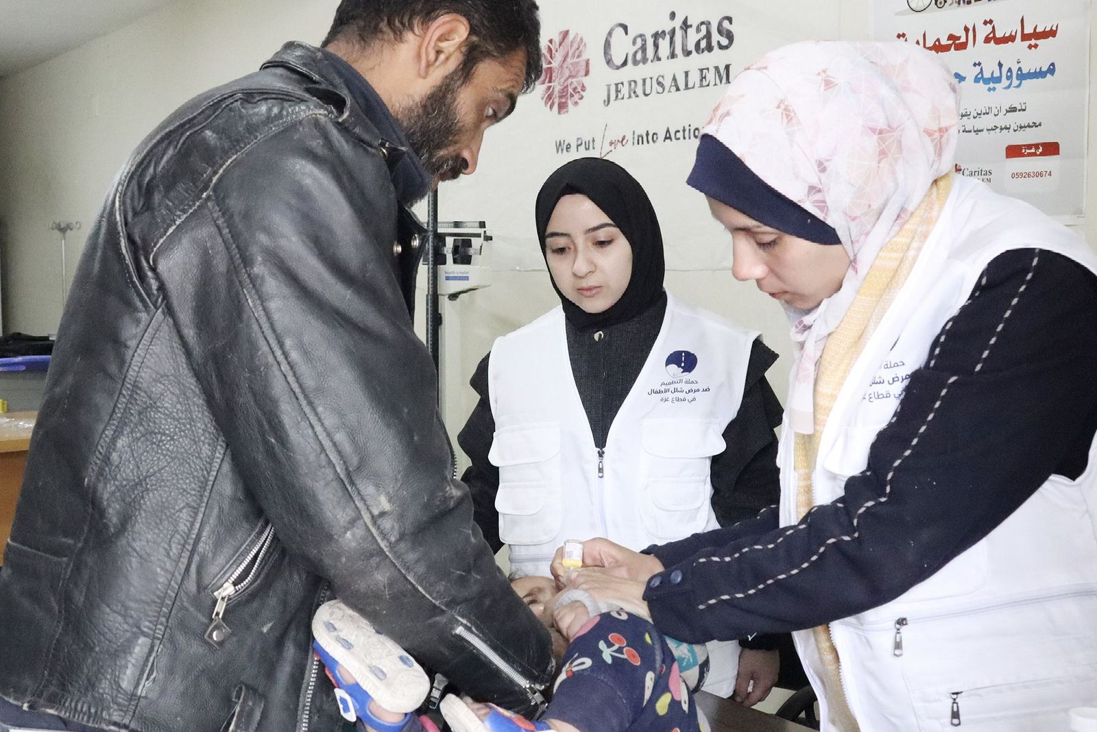Miembros de Cáritas Jerusalén atienden a un niño en un consultorio