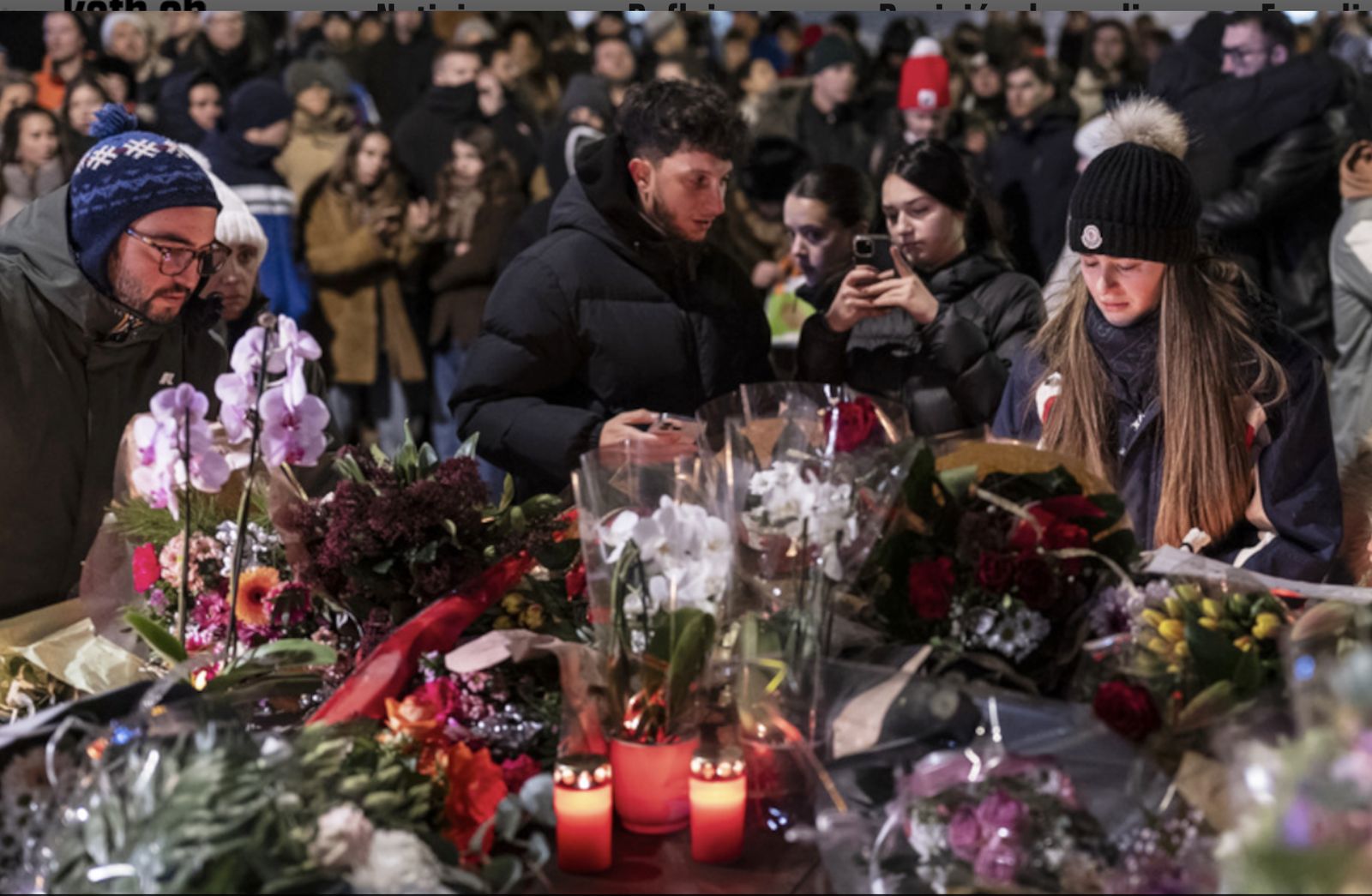 Personas depositan flores frente al bar incendiado