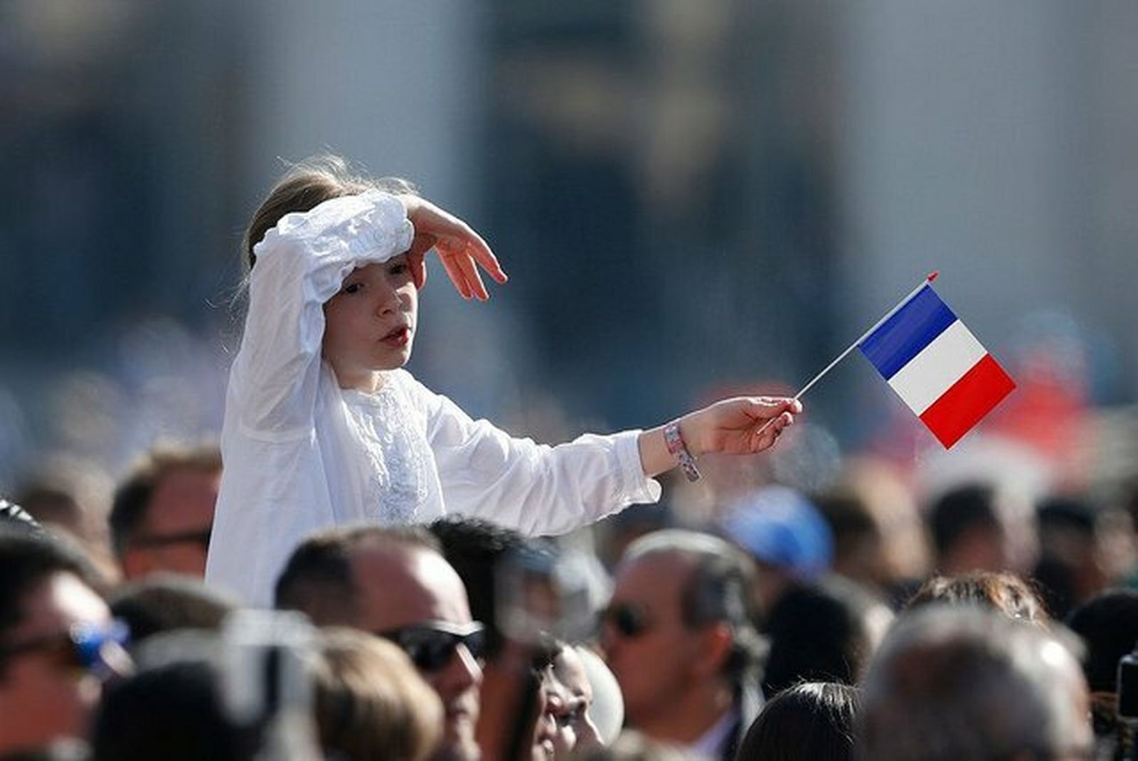 Una niña ondea una bandera francesa