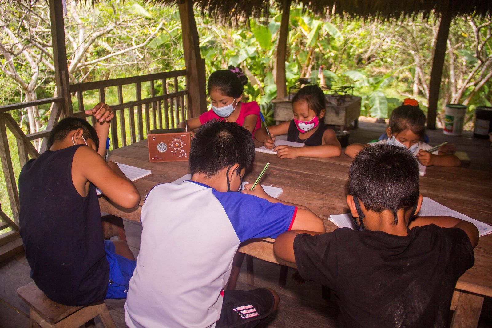 Niños estudiando a través de la radio
