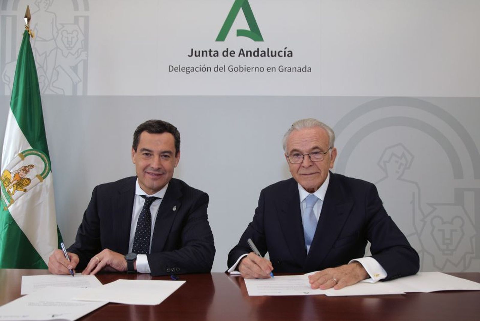 El presidente de la Junta de Andalucía, Juan Manuel Moreno Bonilla, y el presidente de la Fundación ”la Caixa”, Isidro Fainé, en la firma del convenio marco entre ambas instituciones en Granada