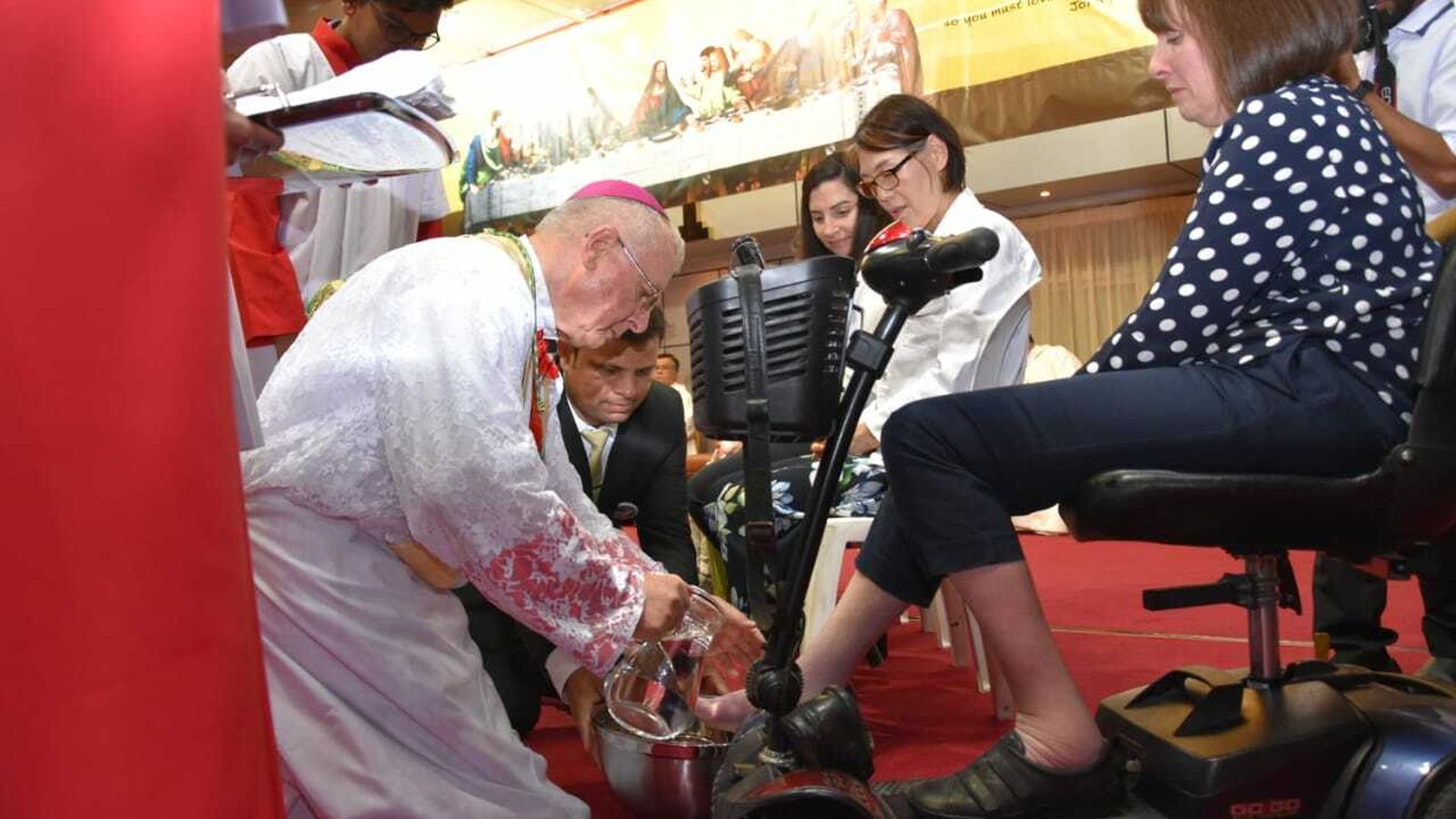 Monseñor Hinder lava los pies a una mujer