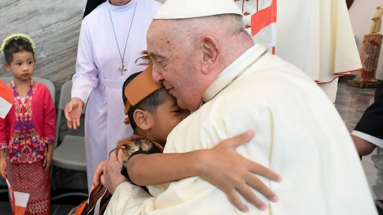 El Papa se abraza con un niño en la Nunciatura de Yakarta