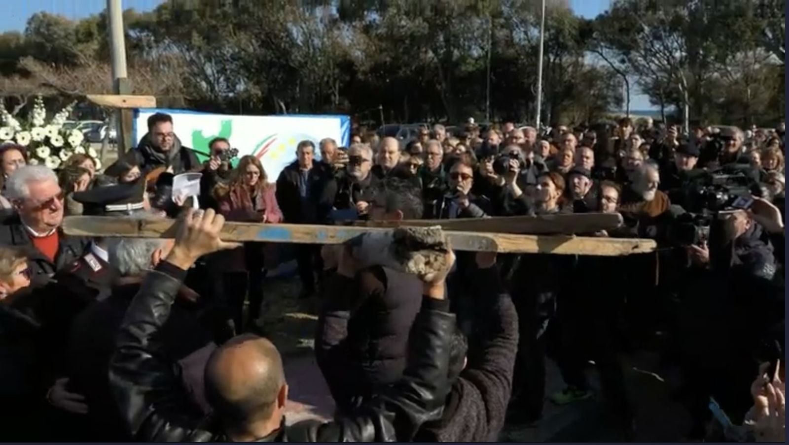 Los fieles trasladan la cruz elaborada con los restos de la embarcación naufragada en Cutro, Italia