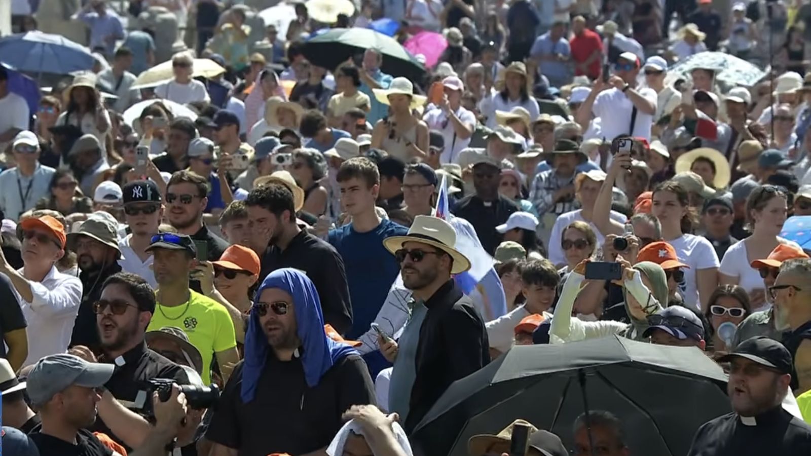 Los fieles se protegen del sol en la plaza de San Pedro