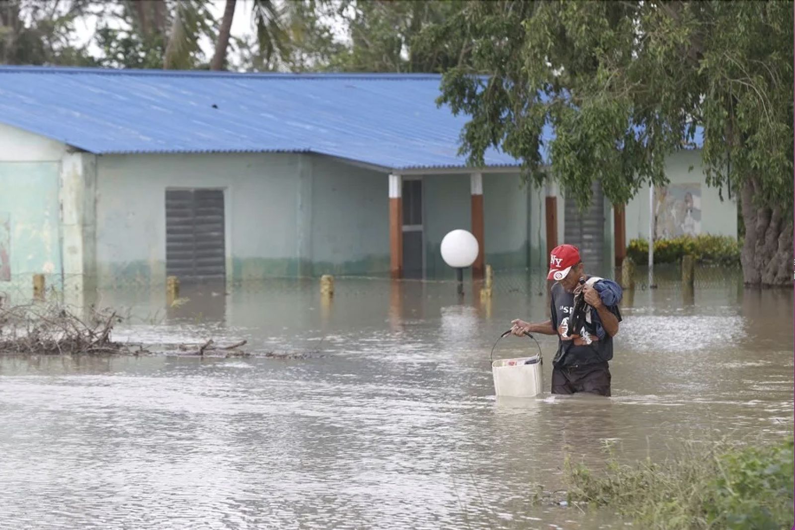 Una persona camina frente a una casa inundada en Cauto Cristo (Cuba)