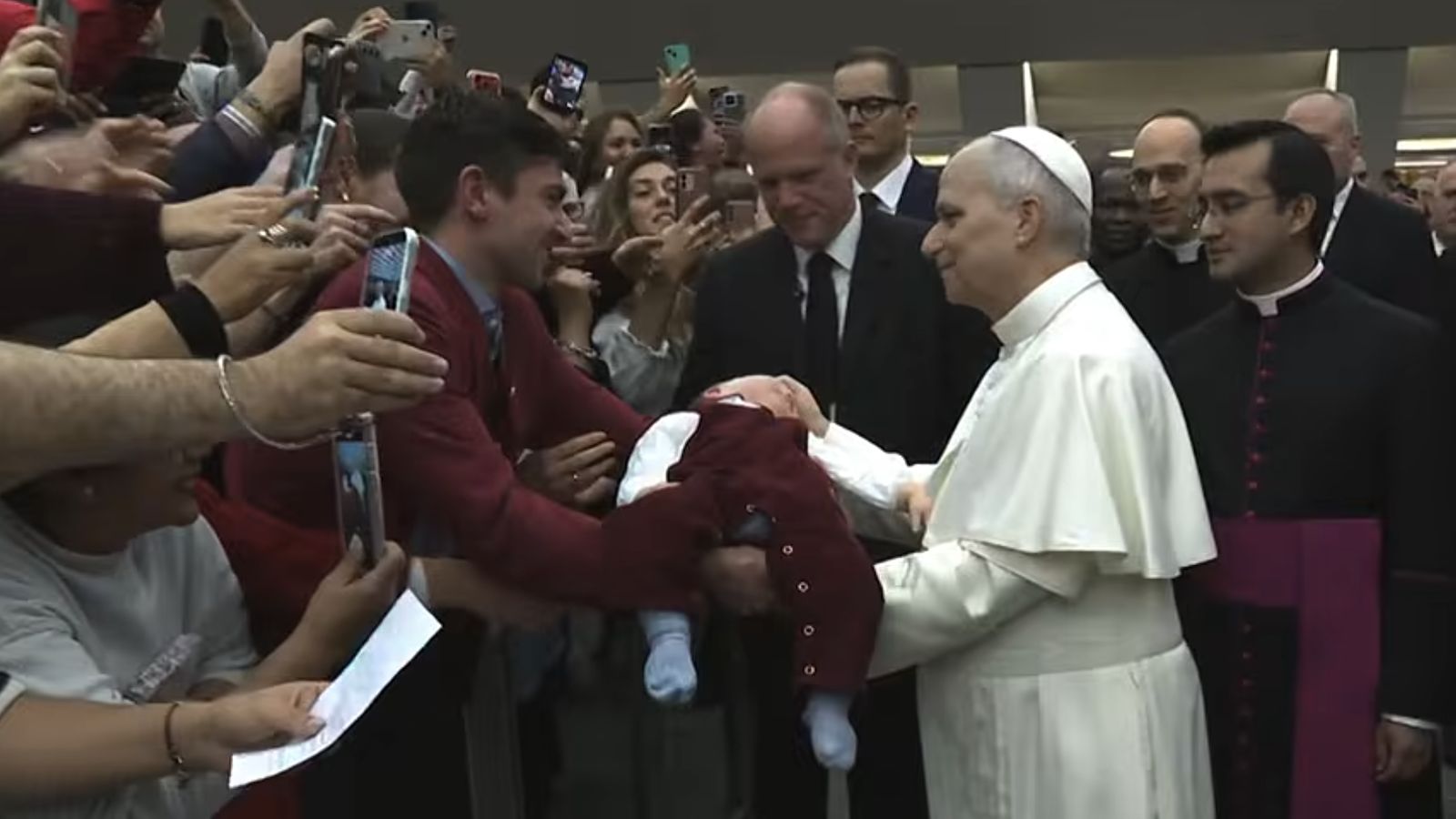 El Papa saluda a la gente y bendice a unniño