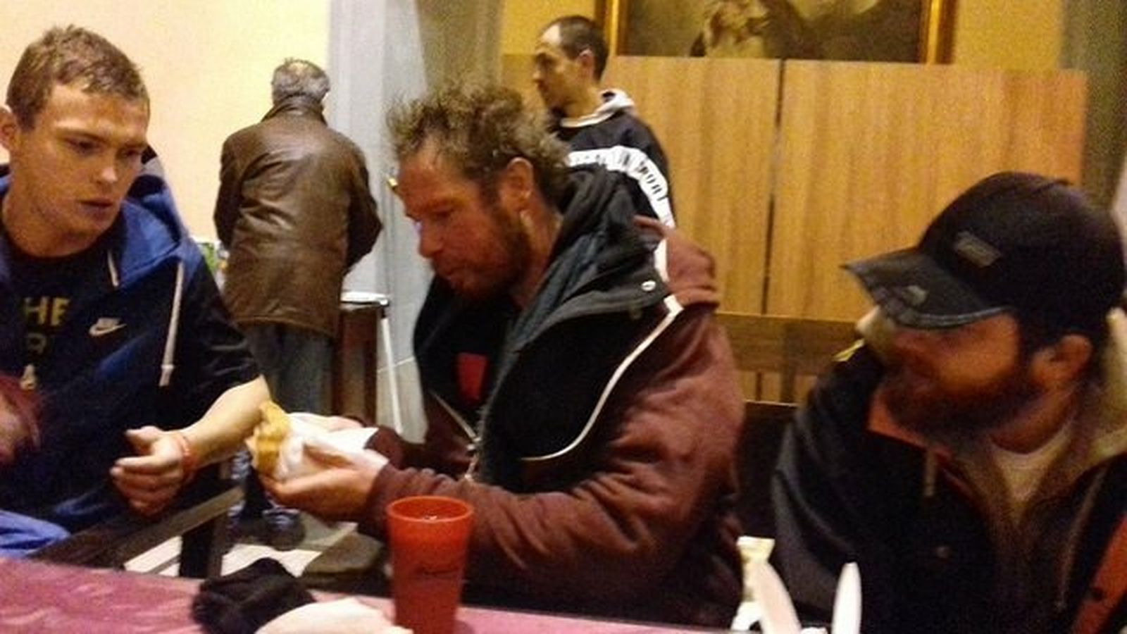 Gente compartiendo comida en la iglesia de Santa Ana, Barcelona