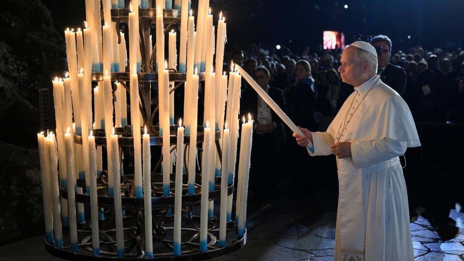 El papa León XIV enciende una vela ante la gruta de las Apariciones de Massabielle, en el santuario de Lourdes.