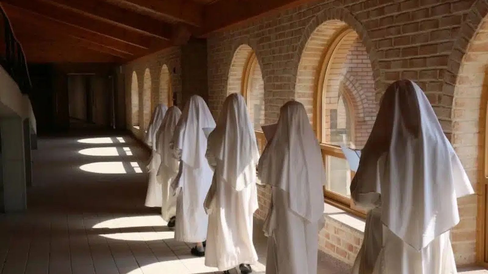 Monjas de la Orden Cartuja recorren los pasillos del monasterio mientras leen.