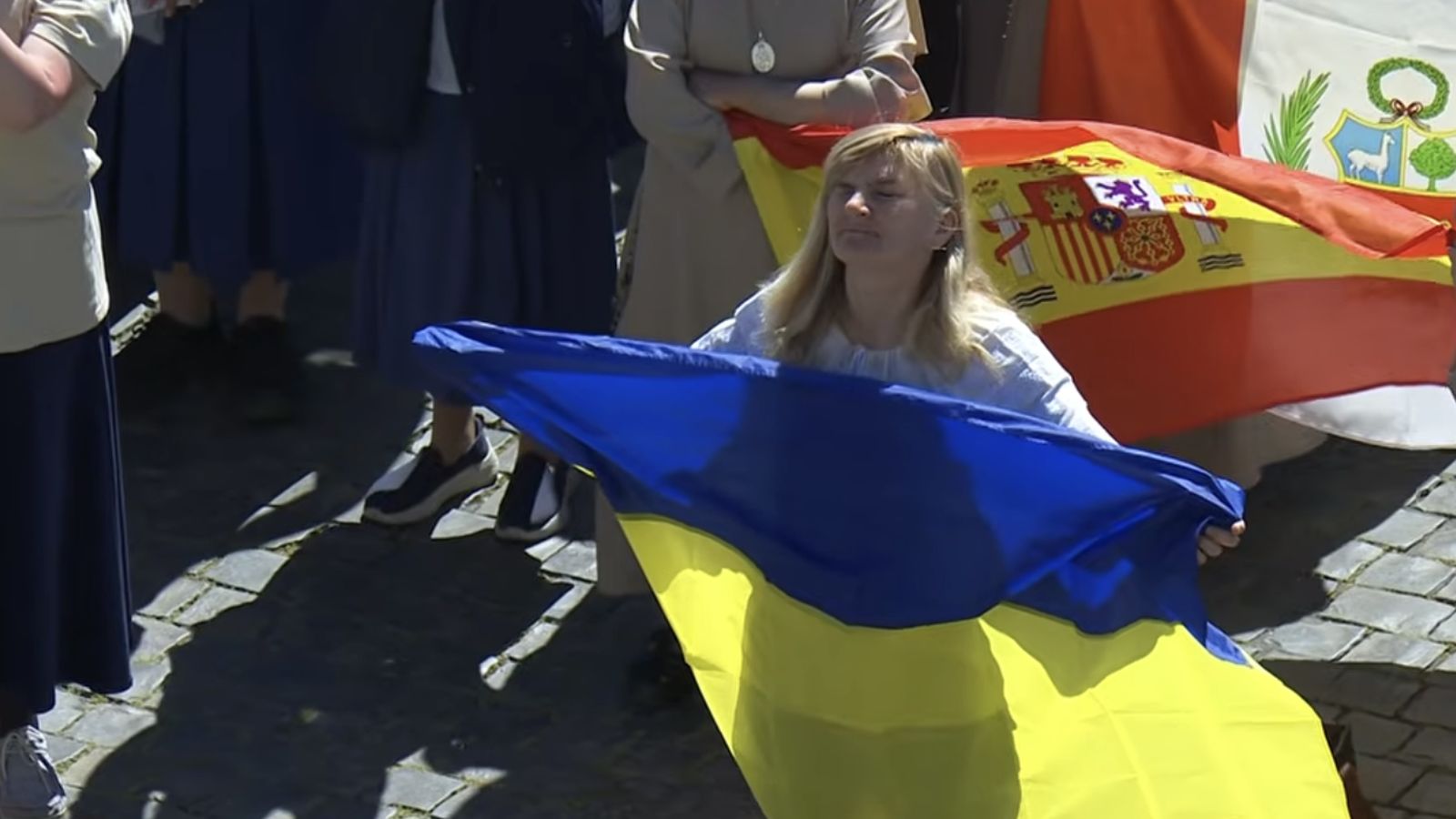 Fieles con banderas de Ucrania, España y Perú