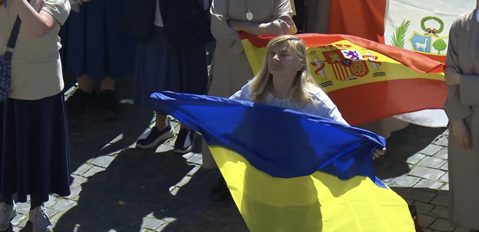 Fieles con banderas de Ucrania, España y Perú