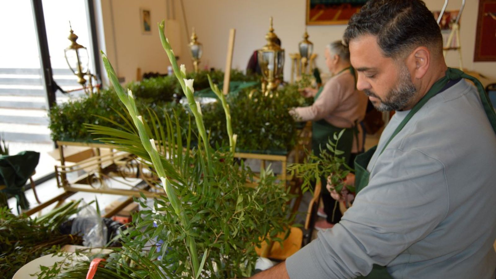 Los portadores ajustan los pasos y ornamentos antes de la procesión nocturna del Viernes Santo, bajo la supervisión de Guzmán.