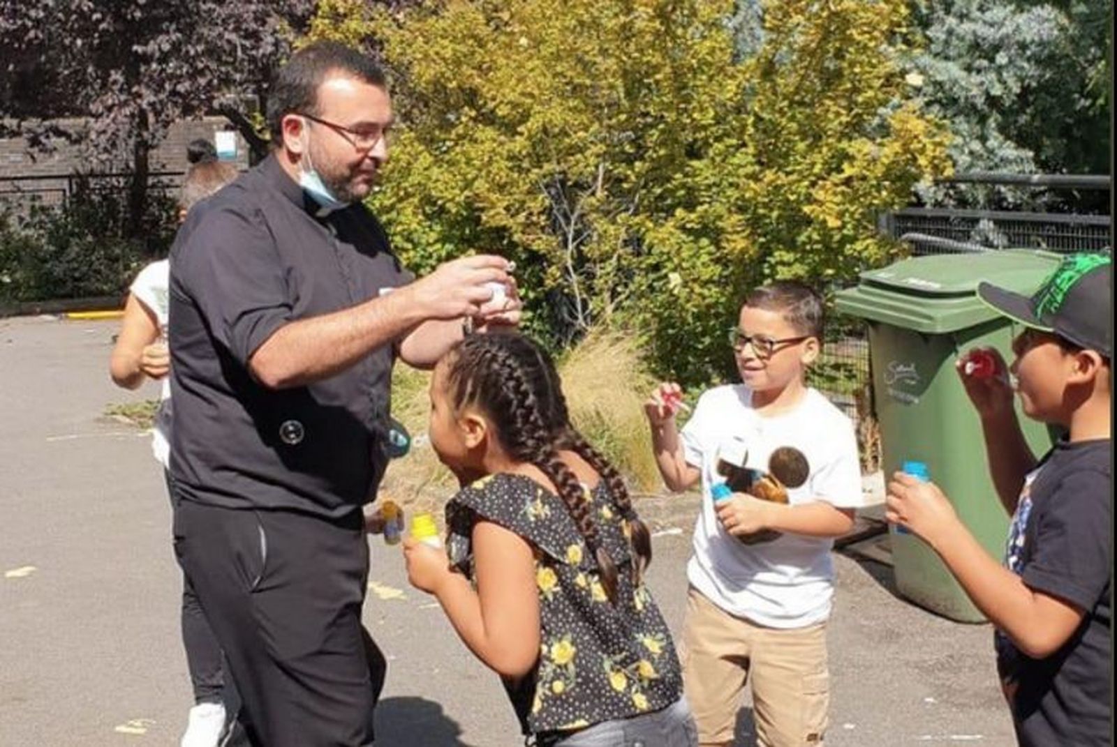 El padre Hugo juega con niños de su parroquia