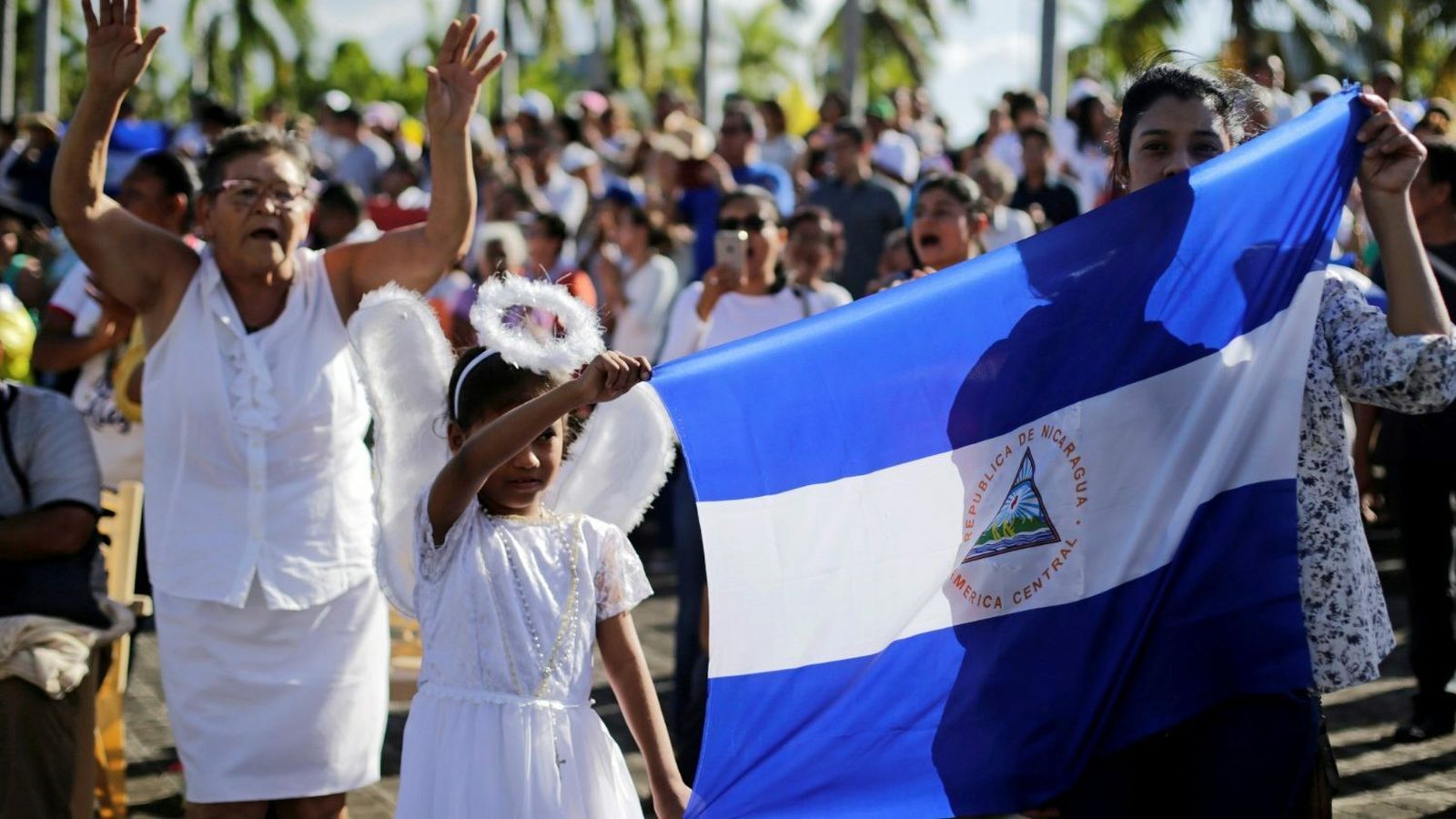 Católicos sostienen bandera nacional durante misa pr la paz en Catedral de Managua