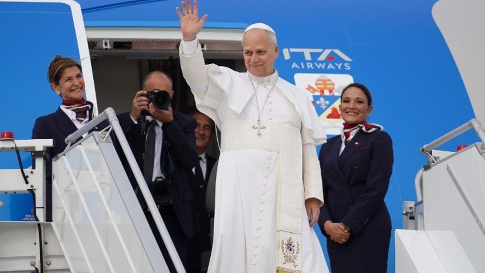 El papa saludando desde la entrada del avión