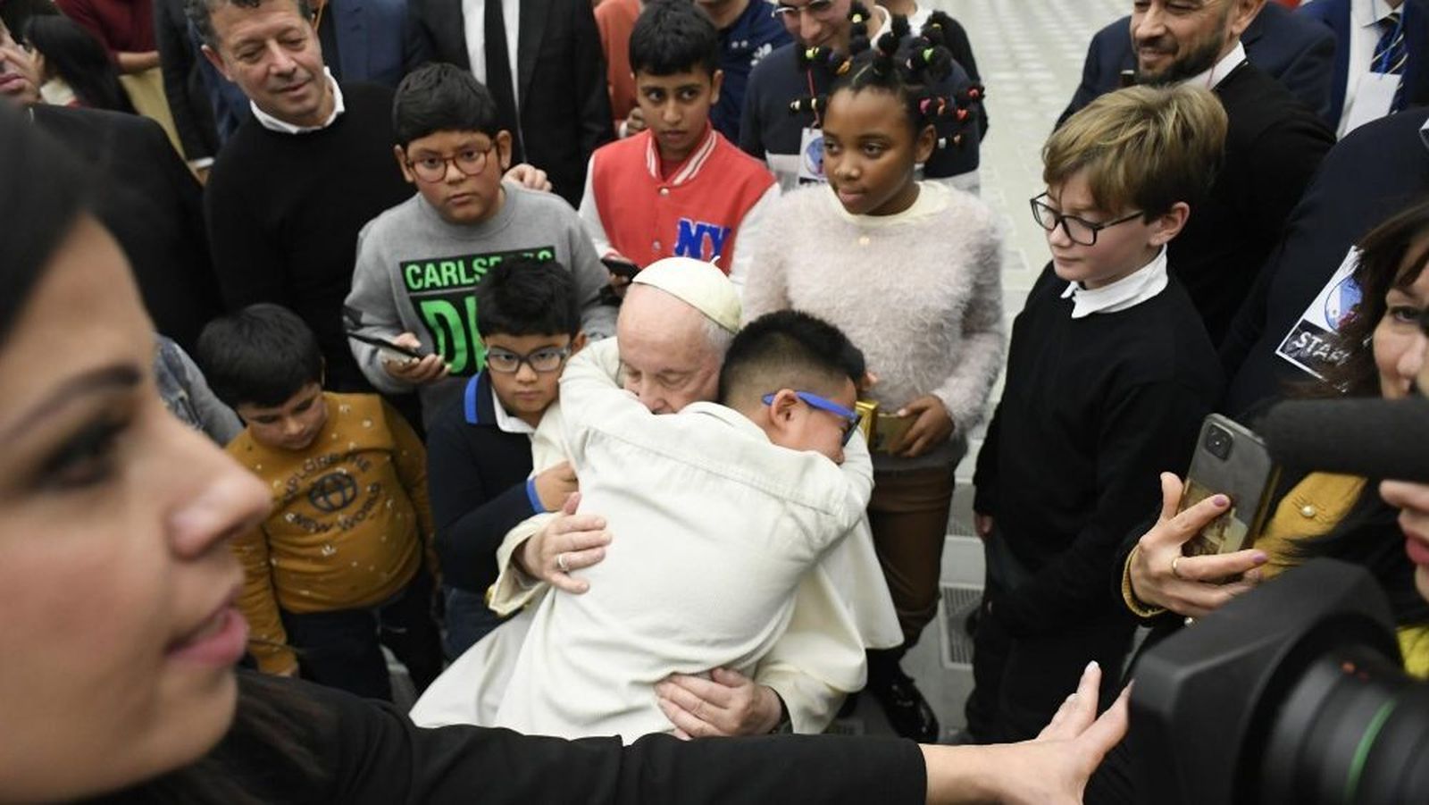 Un niño se abraza al Papa durante su visita al dispensario de Santa Marta