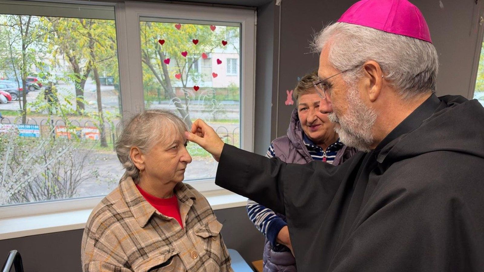 El limosnero del Papa bendice a una mujer en Ucrania