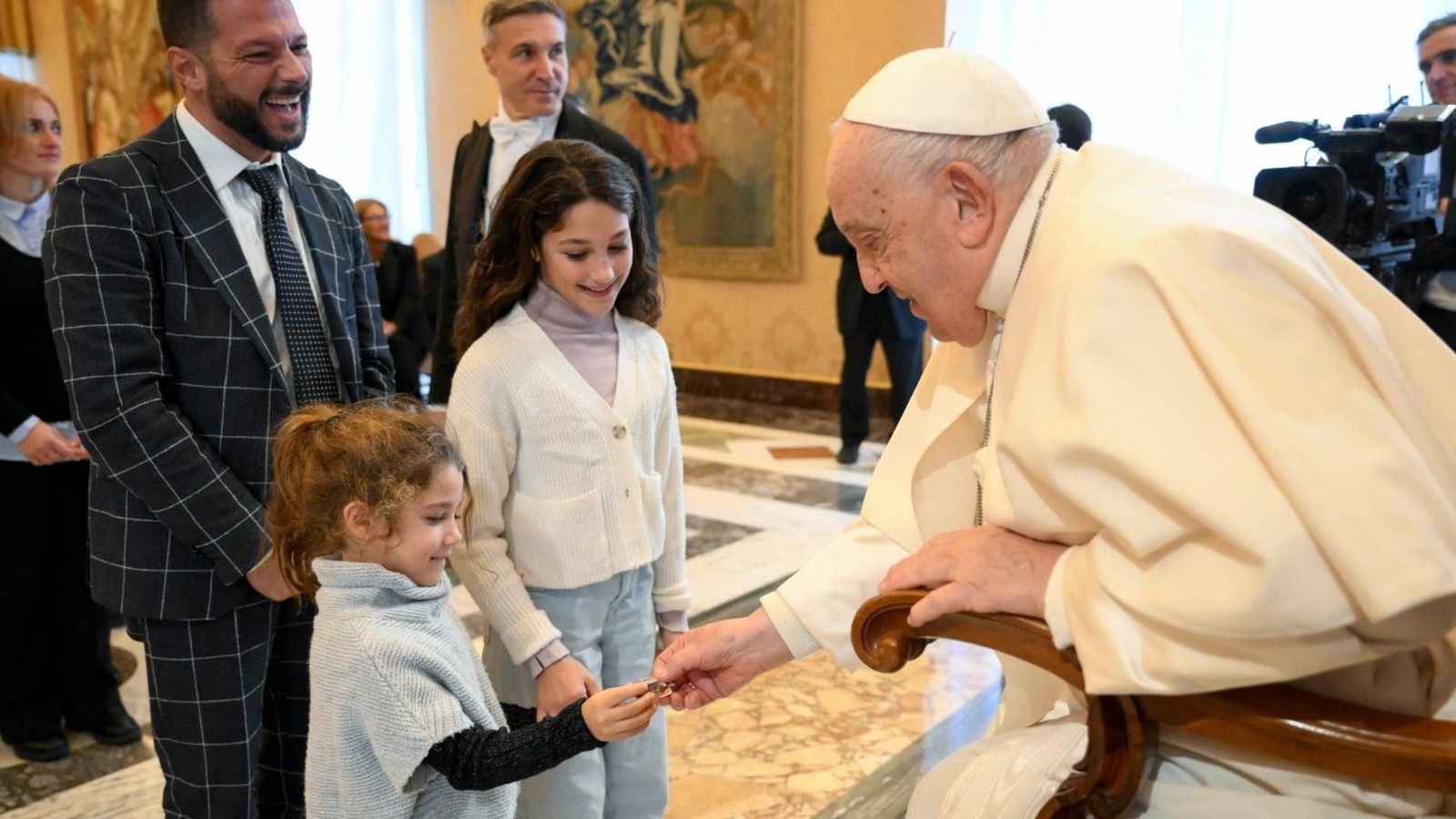 El Papa da unos caramelos a unos niños en la audiencia