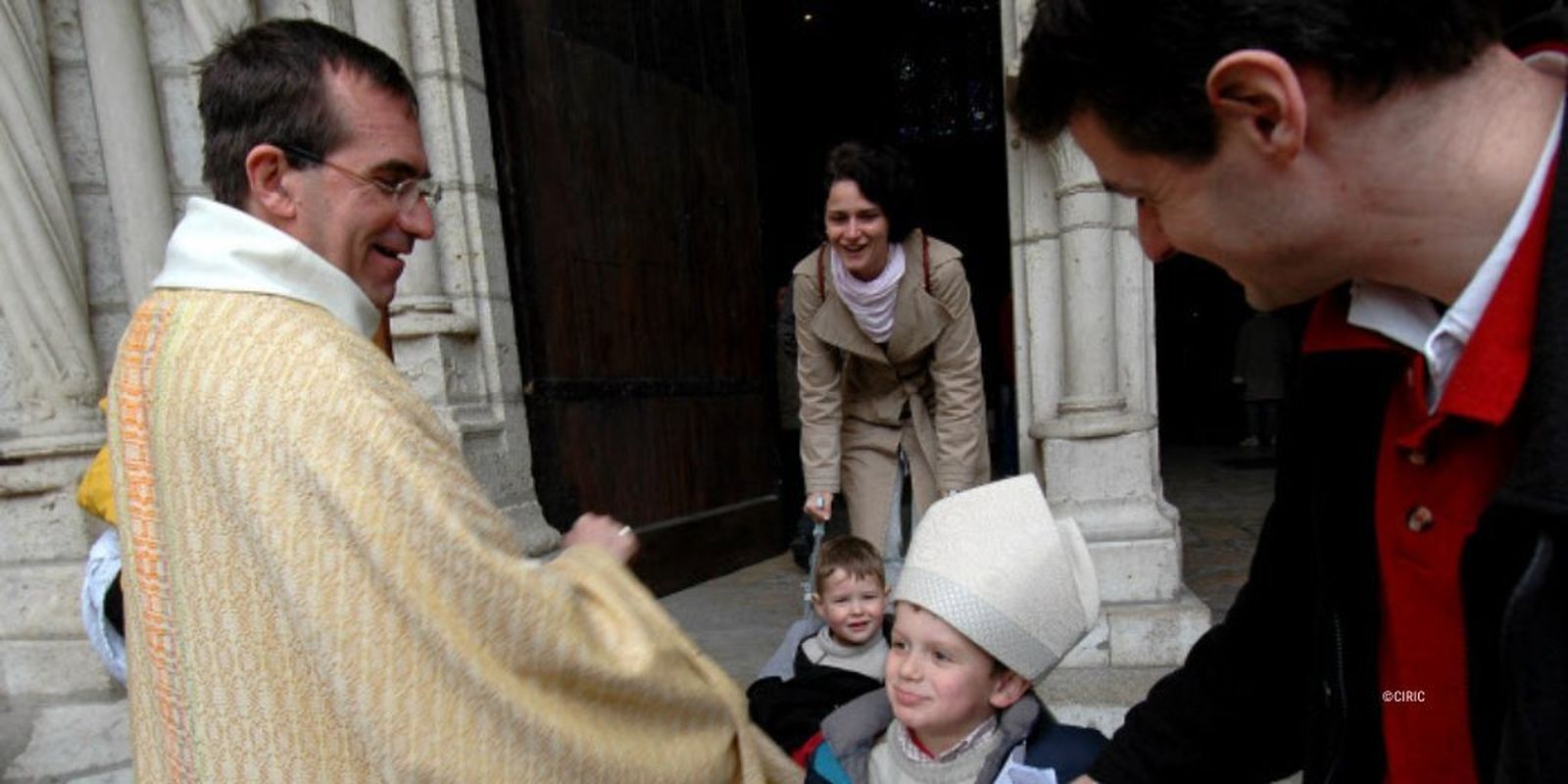 El obispo Michel Pansard, que cumple 15 años como prelado, junto a unos pequeñso feligreses