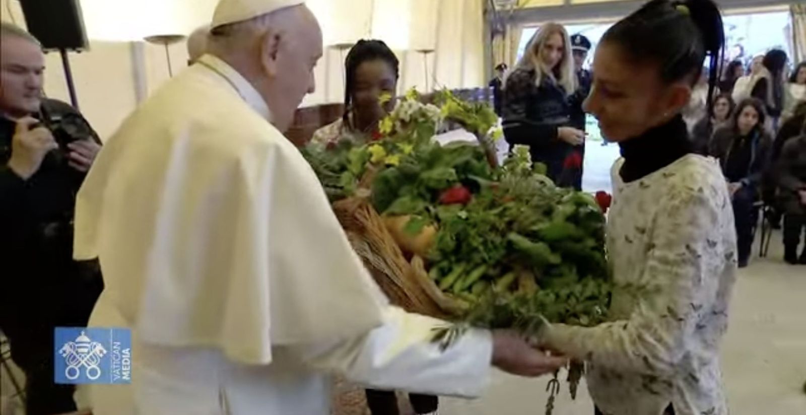 Unas jóvenes presas entregan un regalo elaborado por ellas en la cárcel