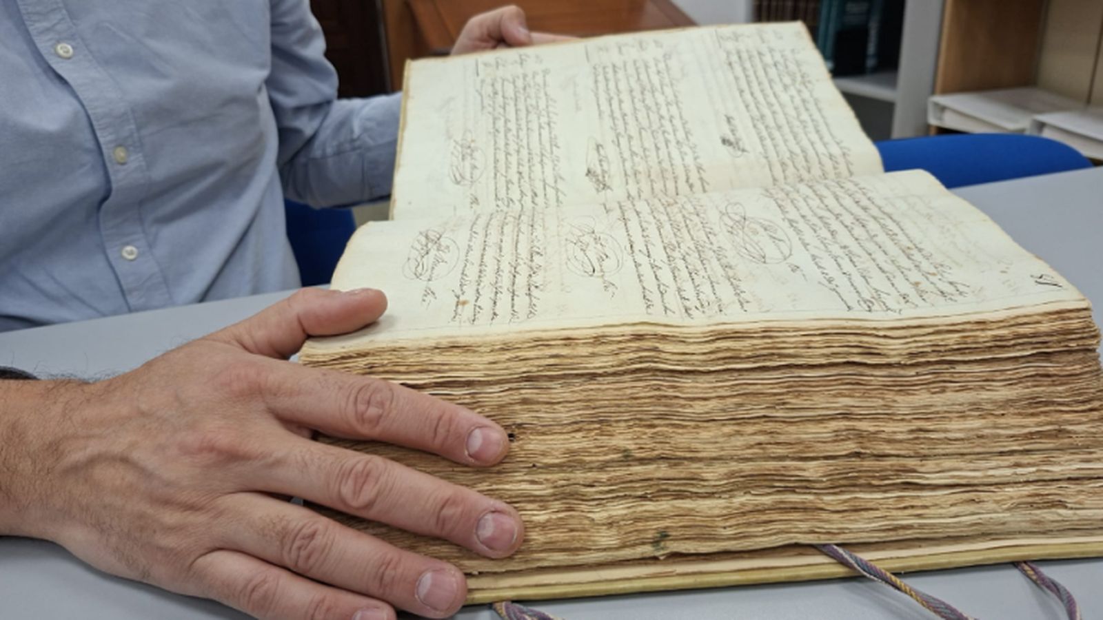 Joan Maria Quijada muestra el volumen bautismal donde figura por primera vez el nombre de Antoni Gaudí, conservado en el Archivo Histórico Archidiocesano de Tarragona.